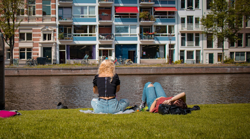 Two women are enjoying rest in the park next to a canal in Amsterdam. Relax in Amsterdam after a hard night or after work.