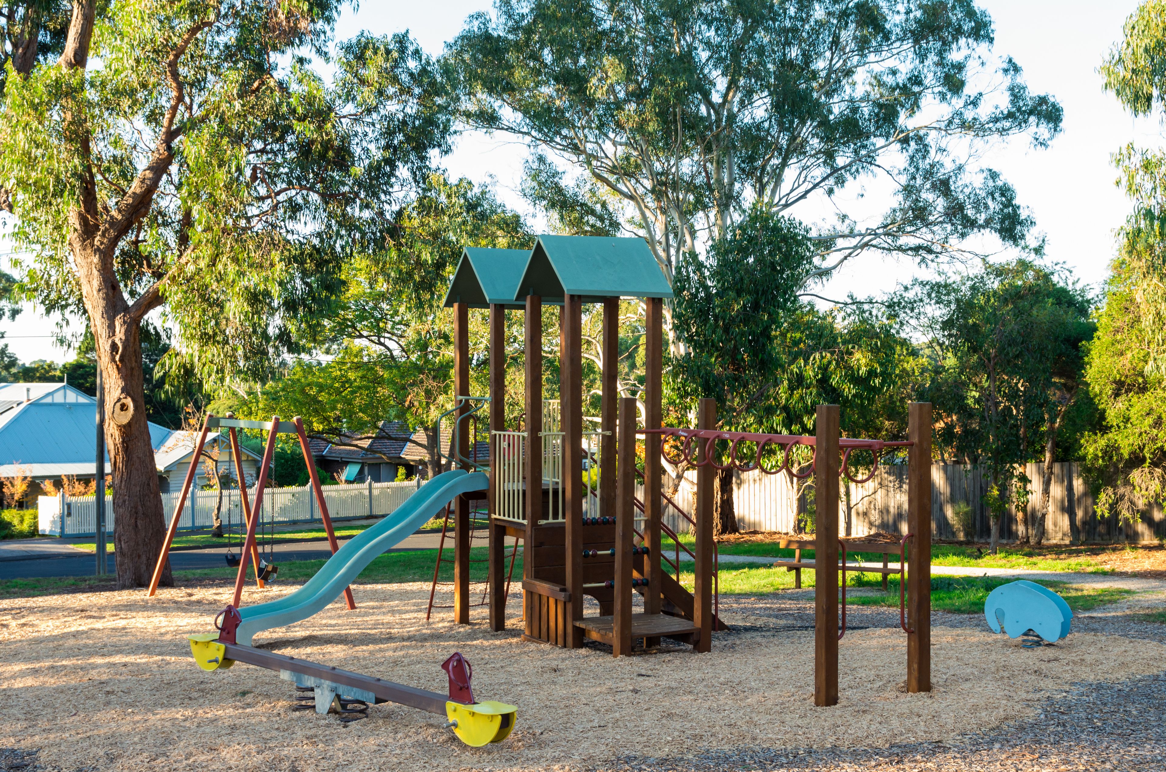 A playground with a seesaw, slide, and climbing structure.