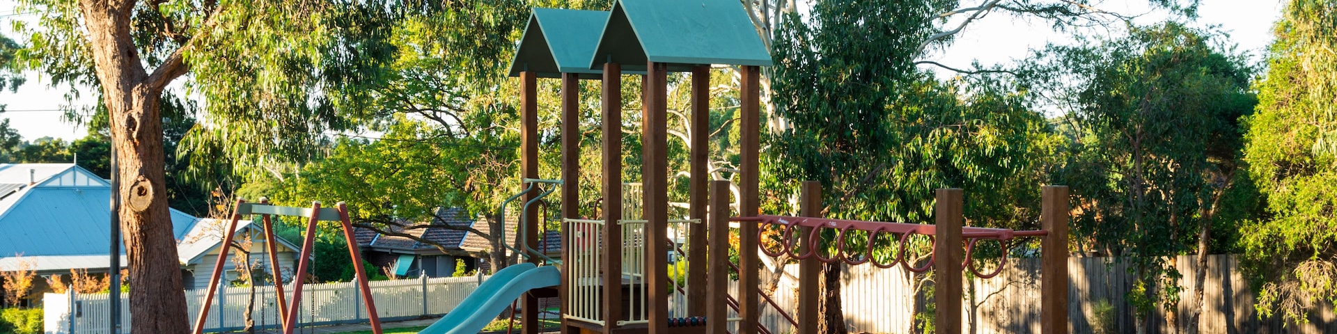 Un parque infantil con sube y baja, tobogán y estructura de escalada.