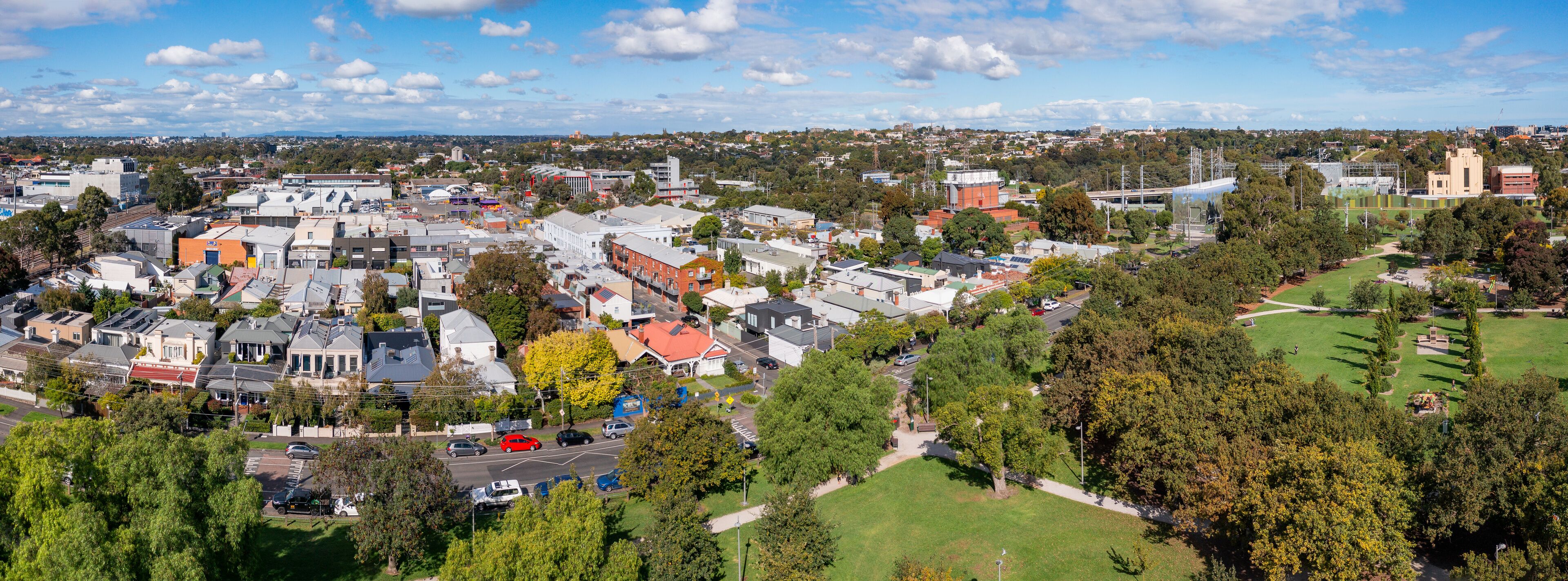 A town with a mix of residential and commercial buildings, a prominent church, and a large open park area.
