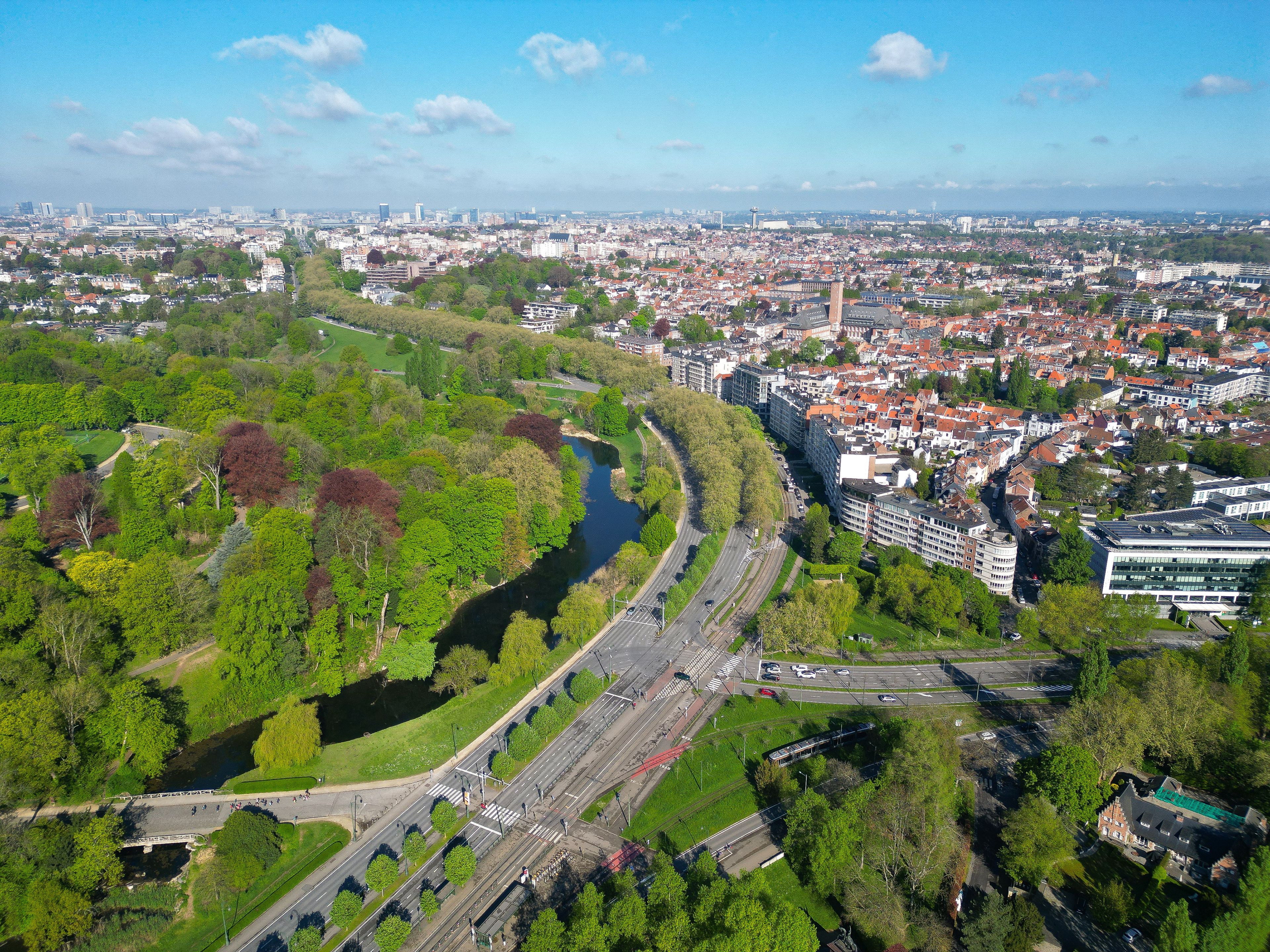 Luchtbeeld van een stad met een rivier, groene parken en een combinatie van moderne en traditionele architectuur.