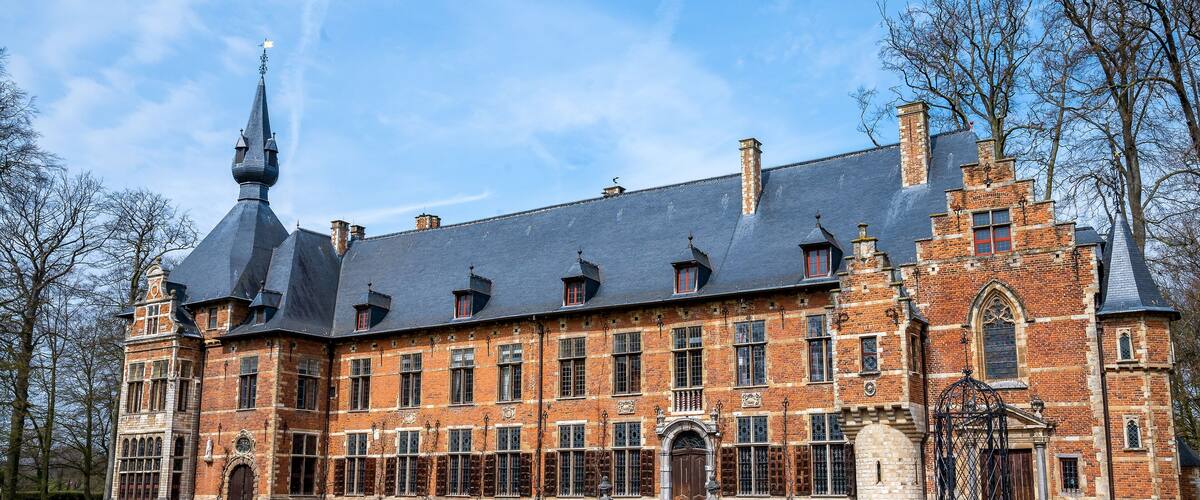 A large, historic brick building with a prominent tower and multiple windows.