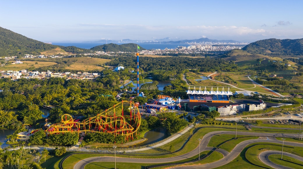 Aerial view of Beto Carrero World with roller coaster and cityscape of Balneário Camboriú in the background.