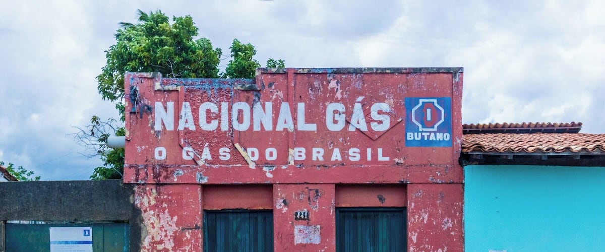 A building with a sign reading "Nacional Gas O Gas do Brasil" and a blue and red exterior.