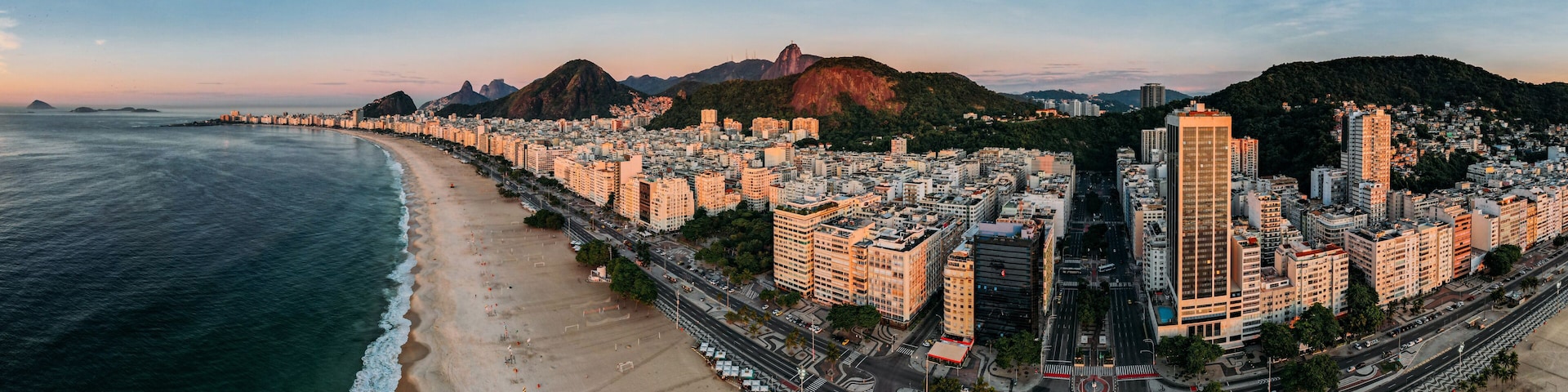 Un paisaje urbano costero con una montaña destacada y una playa.