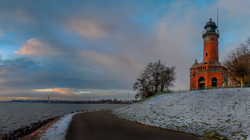 Winter on the Kiel fjord with snow. Winter on the Baltic sea. Holtenau lighthouse at the mouth of the Kiel Canal on the Kieler Förde in winter.