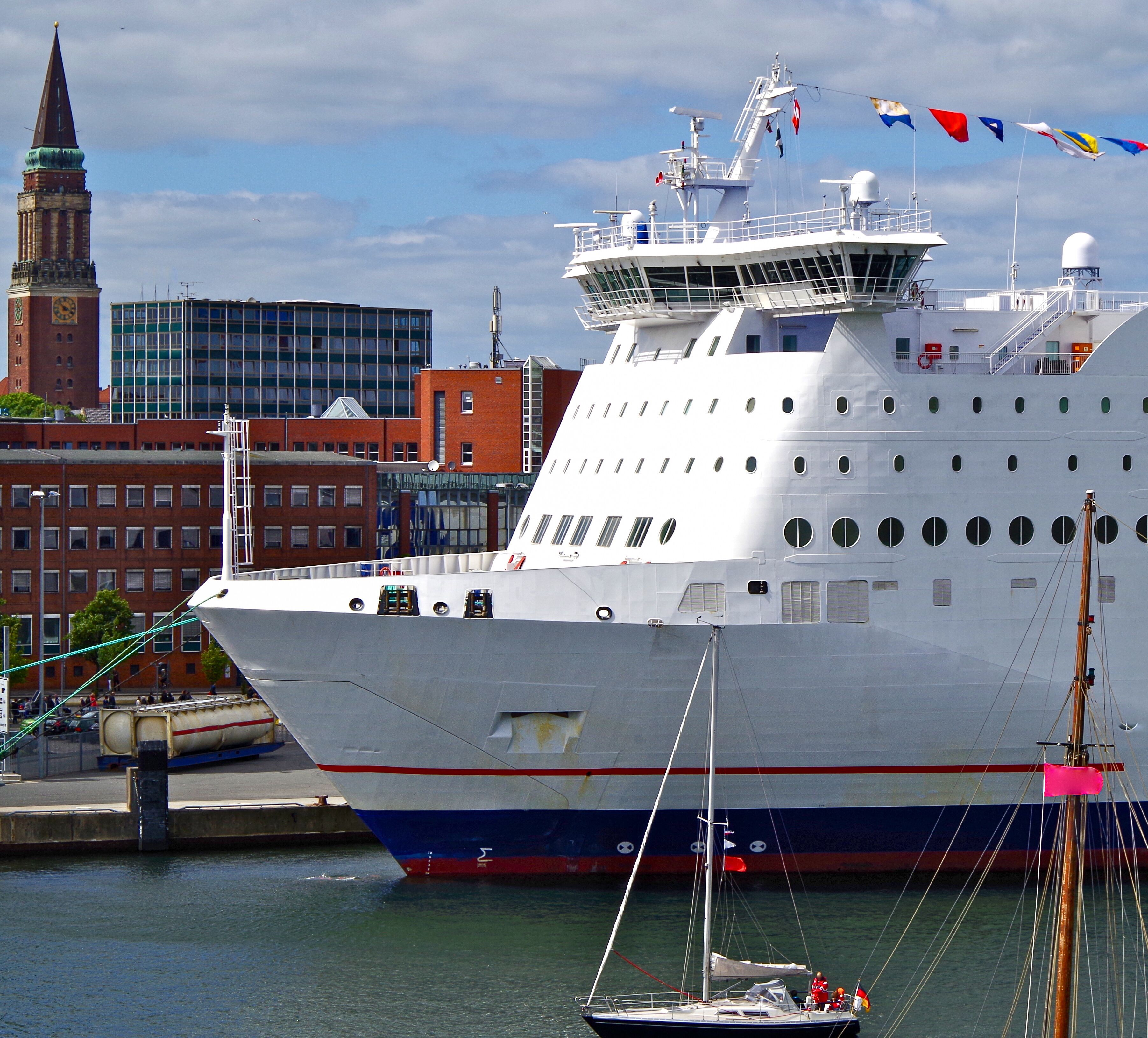 Passenger ferry Stena Line with sailing boats in port of Kiel, Germany with clocktower of cathedral and buildings in background during Kieler Woche Sailing Week