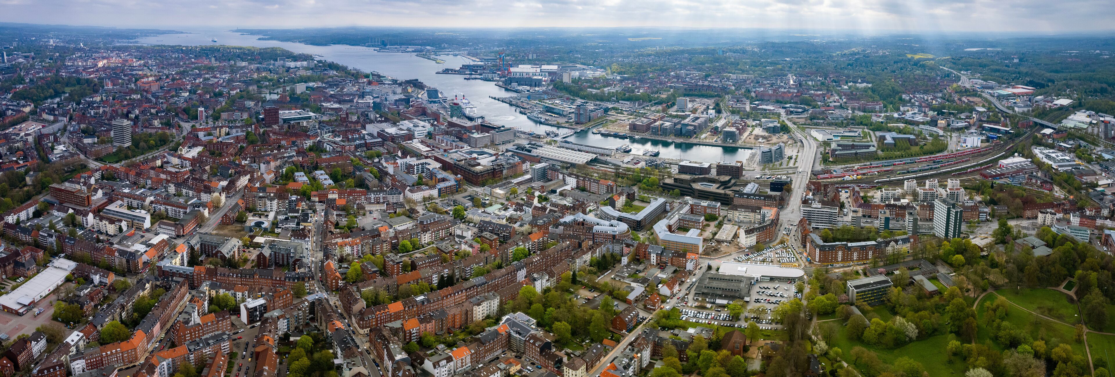 An aerial view of a city with a river, bridges, and a large stadium.