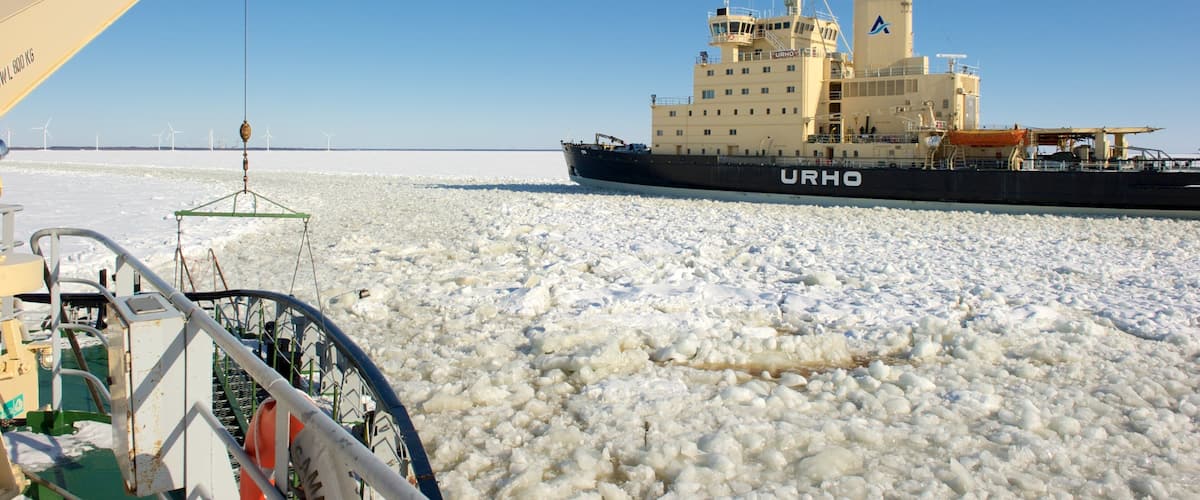 A ship named URHO navigating through a field of ice.