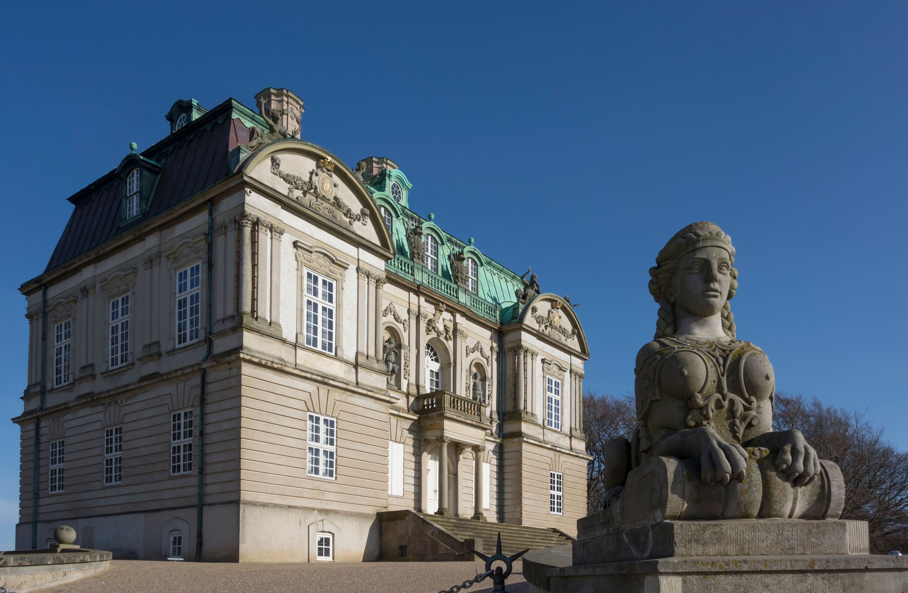 A historic building with ornate architecture and a statue in front.