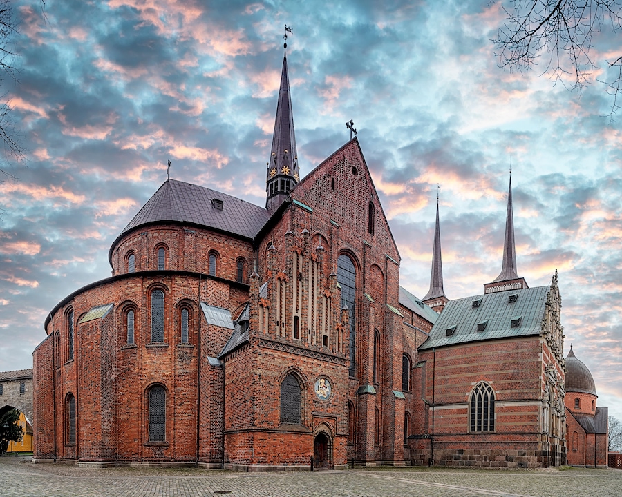 En historisk kirke med et markant spir og en kuppel.
