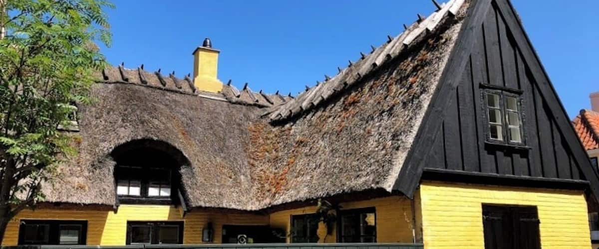 A traditional building with a thatched roof and yellow walls.