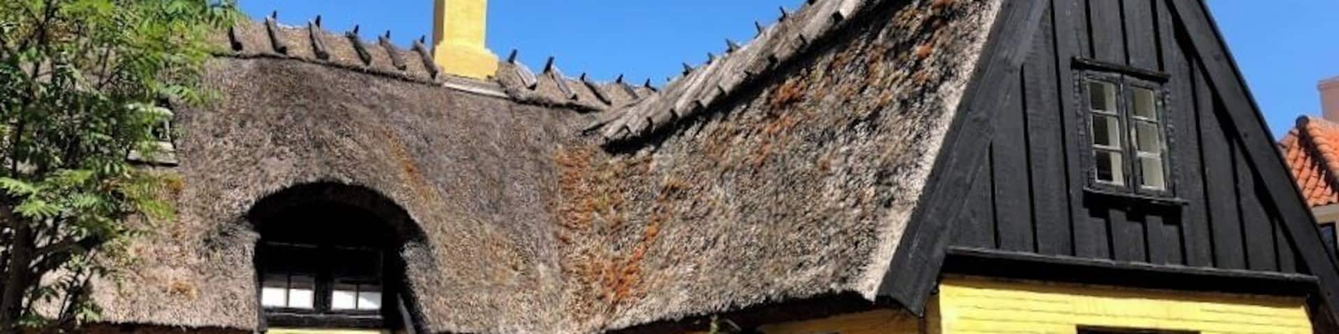 A traditional building with a thatched roof and yellow walls.
