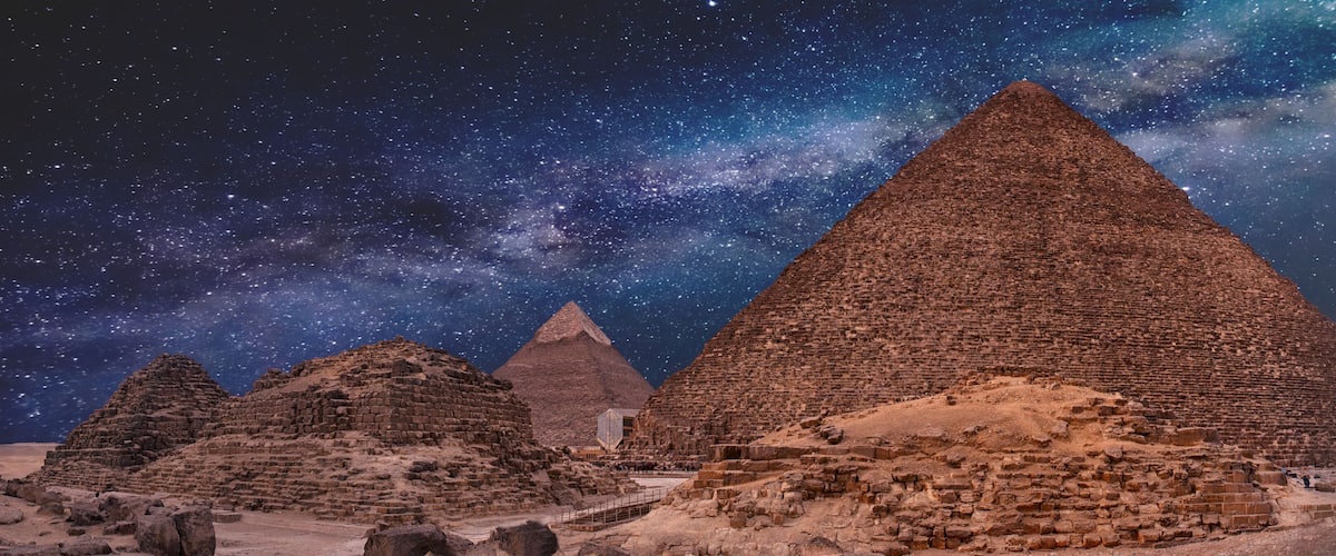 Night sky of the Milky Way over the great pyramids on the plateau of Giza, Egypt, Africa.