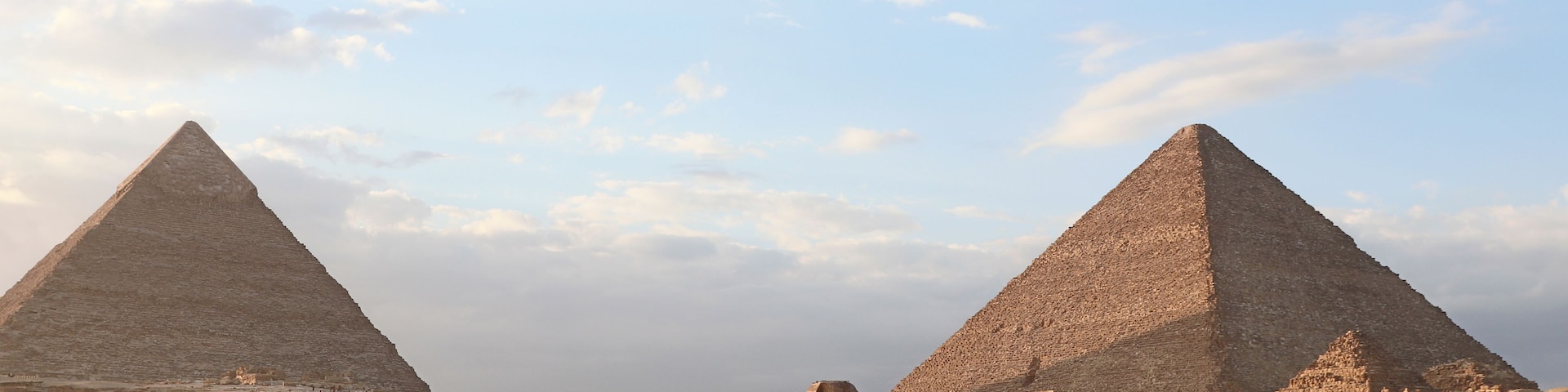 Zwei große Pyramiden, eine Wüstenlandschaft und alte Ruinen.