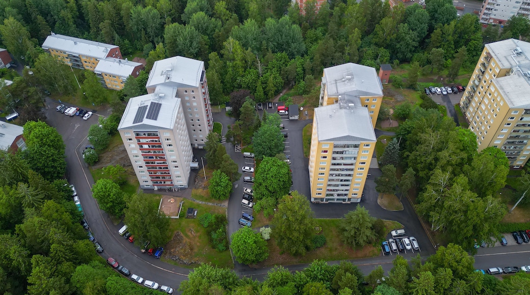An aerial view of a residential area with apartment buildings, roads, and parked cars.