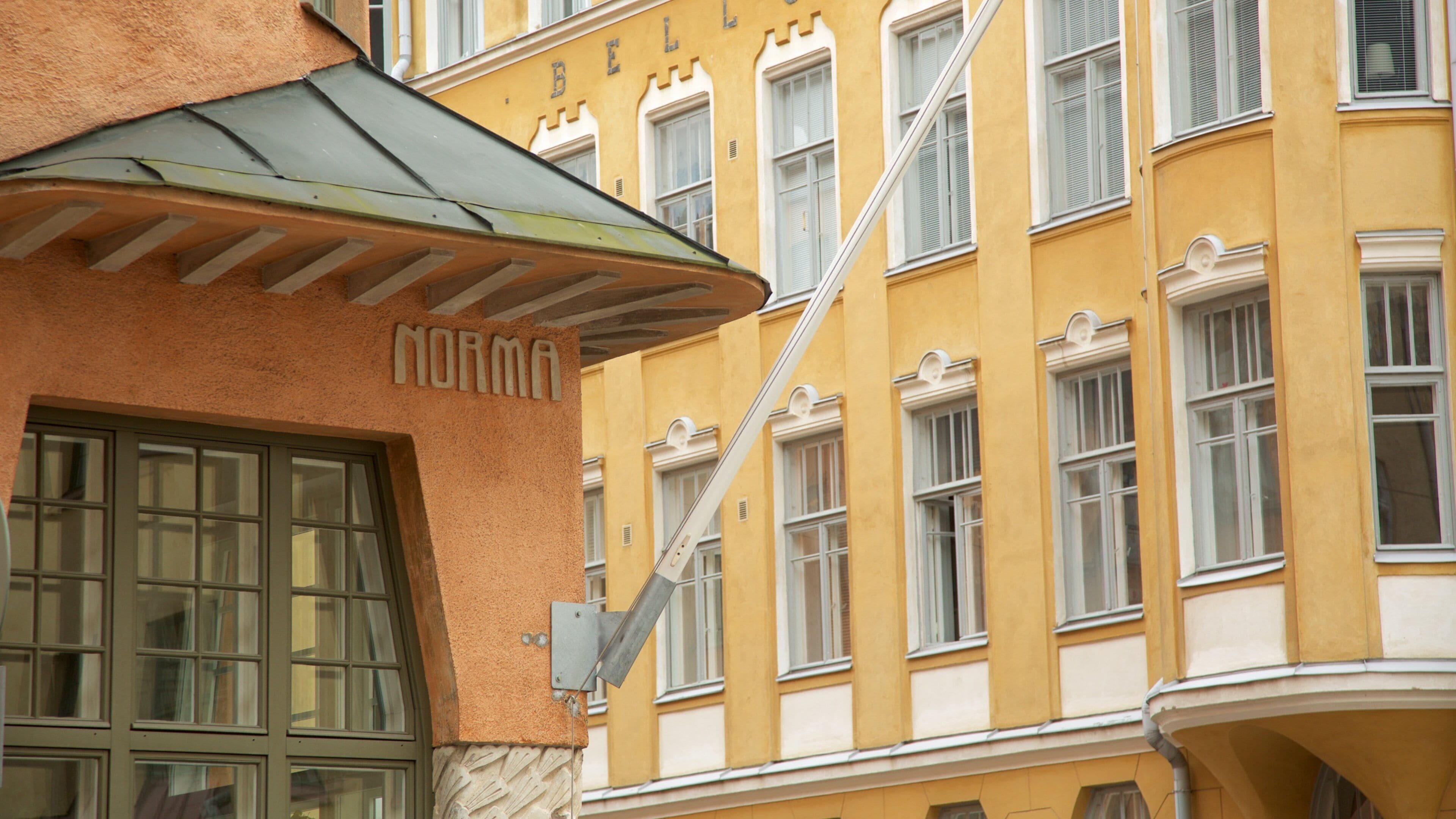 A yellow building with the name "NORMA" and a sign above a window.
