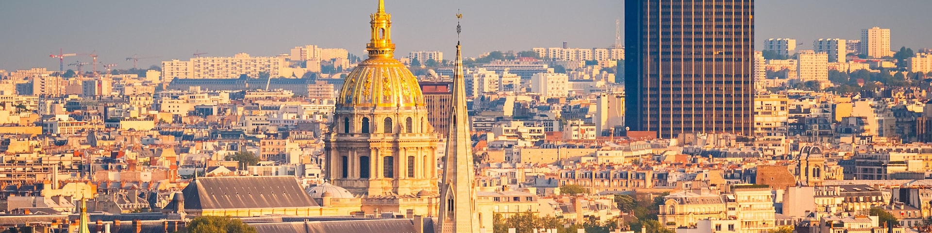 A cityscape with a prominent golden-domed cathedral and a modern skyscraper.