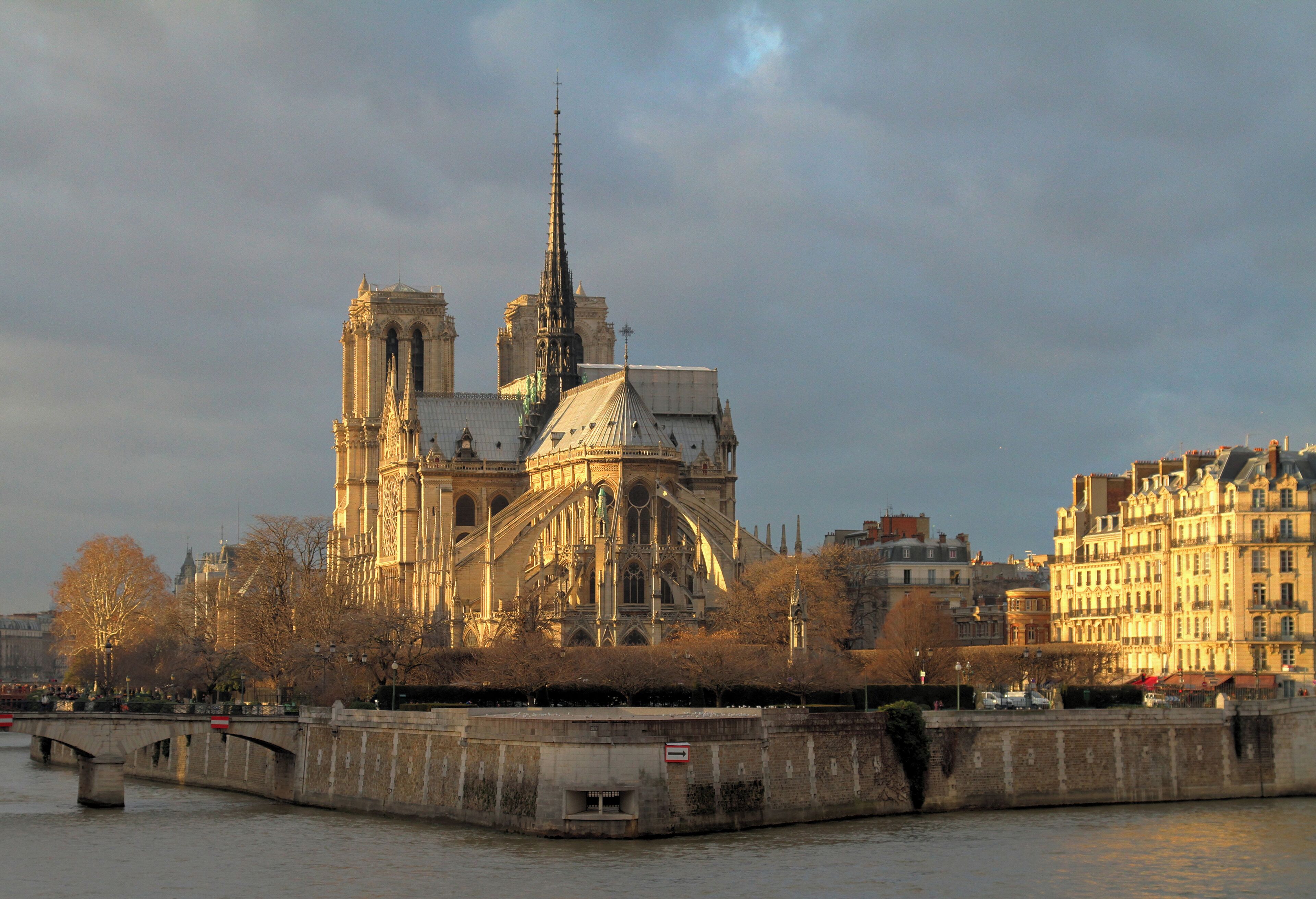 La Catedral de Notre Dame en París, con el río Sena en primer plano y la Torre Eiffel al fondo.