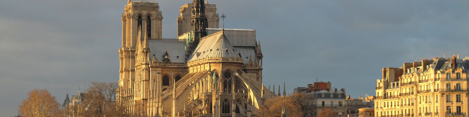 La Catedral de Notre Dame en París, con el río Sena en primer plano y la Torre Eiffel al fondo.