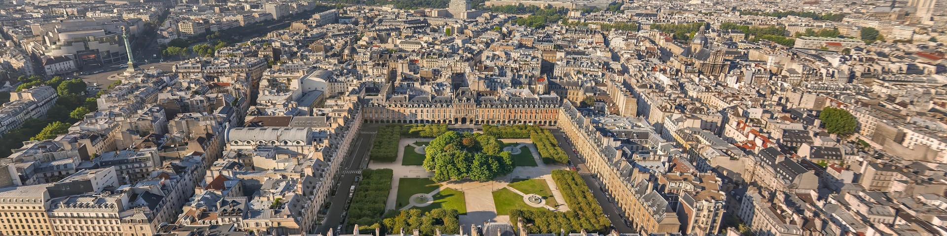 Une vue panoramique d’une ville densément construite, avec une place imposante entourée de bâtiments historiques.