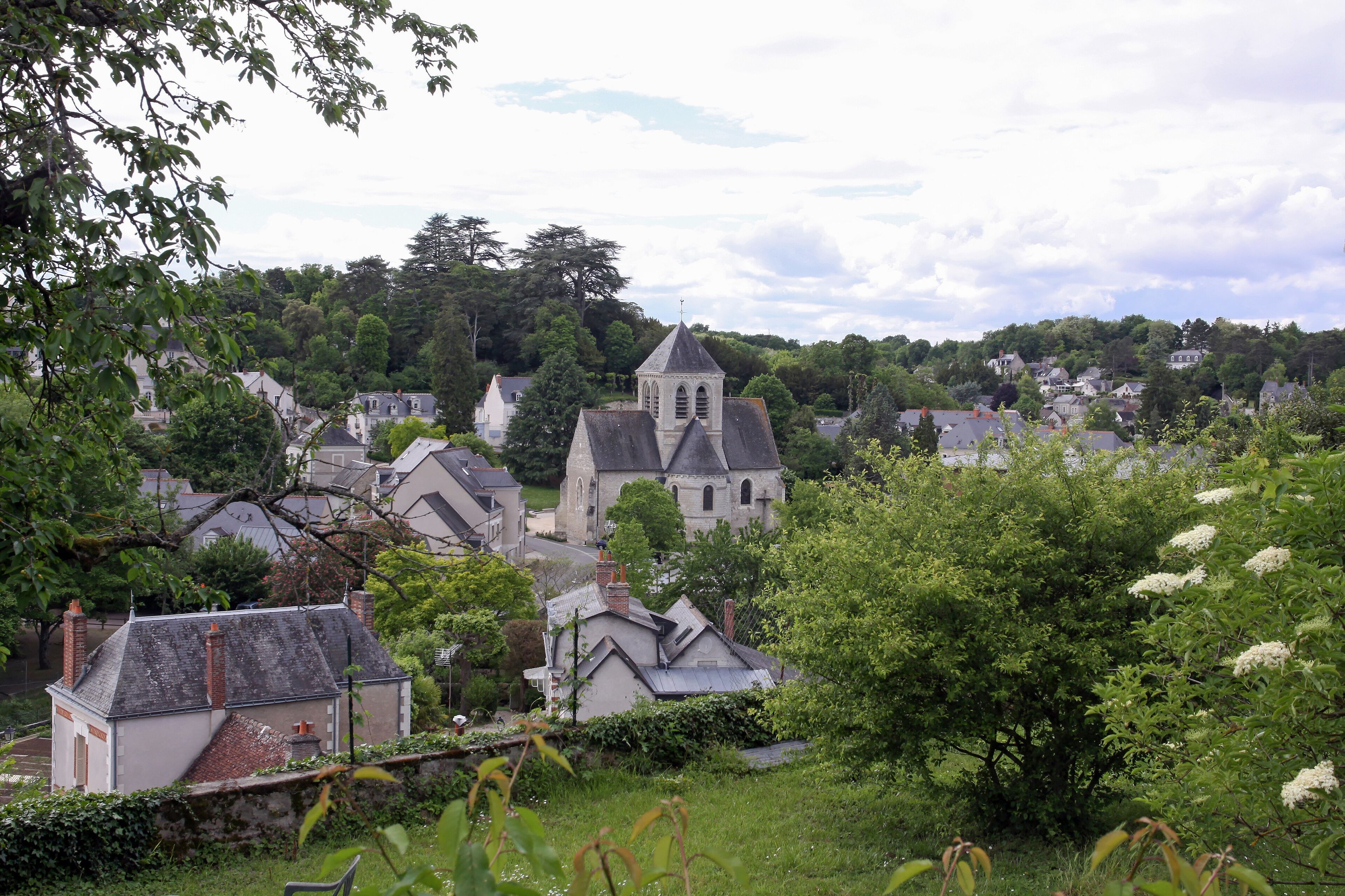 A village with a prominent church, surrounded by lush greenery and residential houses.