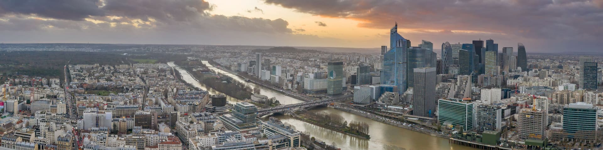 Panoramic aerial drone shot of Neuilly and la defense skyscraper complex in financial cbd area near la seine during sunset hour in Paris