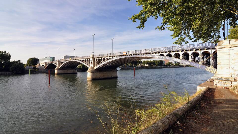 A stone bridge over a river with a clear sky.