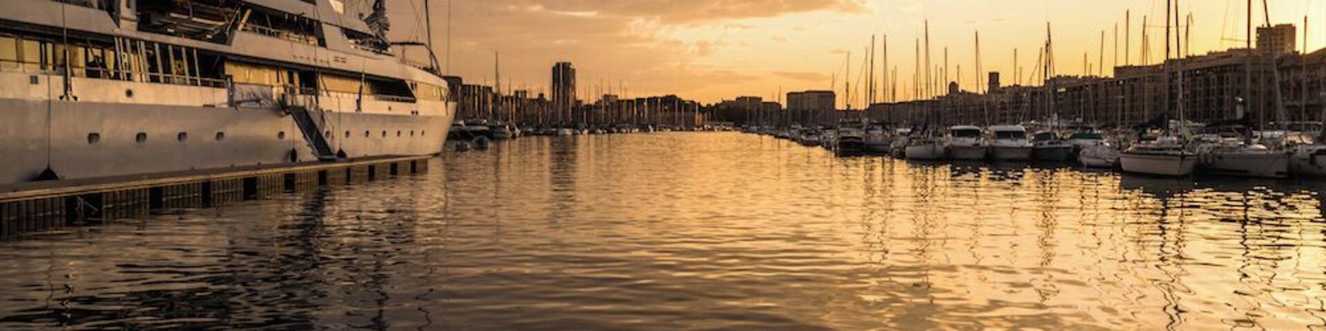 A marina with several sailboats docked at sunset.