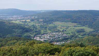 Un paysage montagneux, avec de vastes forêts et une petite ville nichée au fond de la vallée.