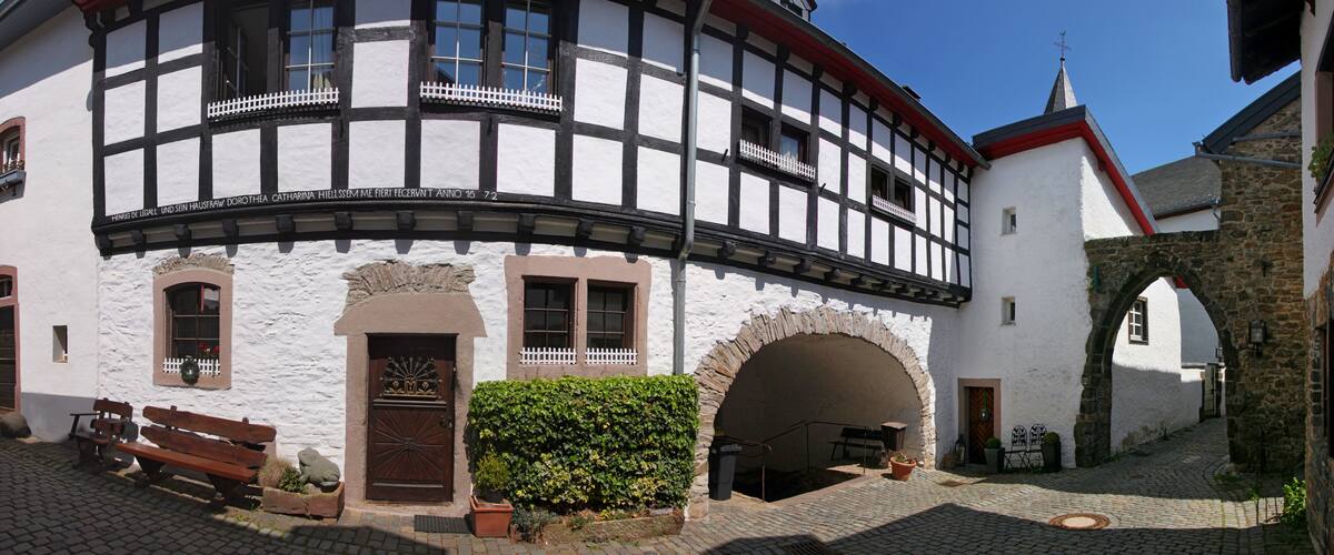A half-timbered building with a white facade and black timber framing.