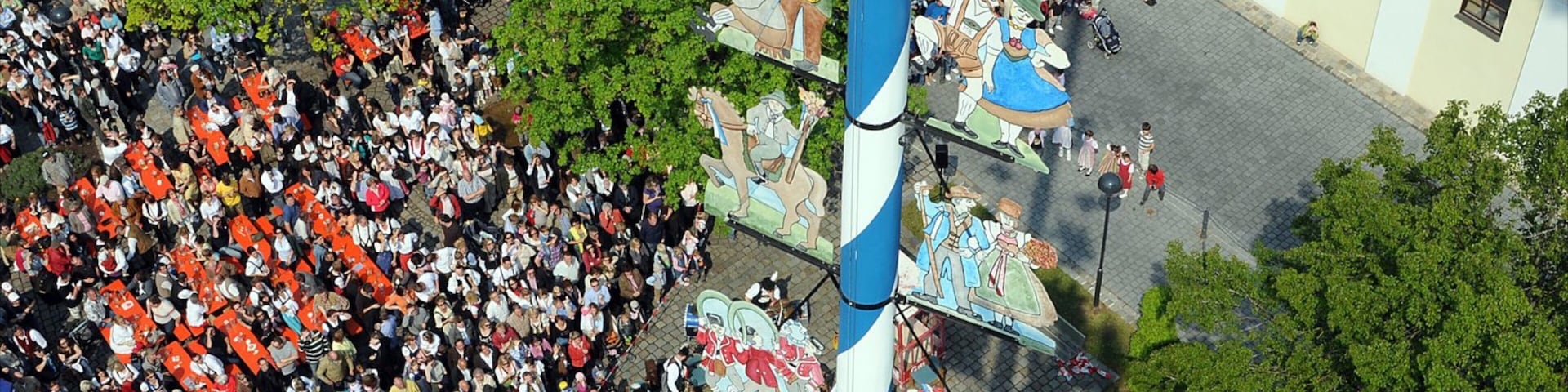 Ismaning mostrando uma cidade pequena ou vila e uma praça ou plaza assim como um grande grupo de pessoas