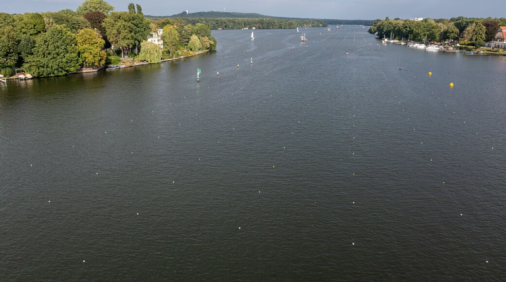 Ein Fluss mit Booten, einem Leuchtturm und einer bewaldeten Gegend.