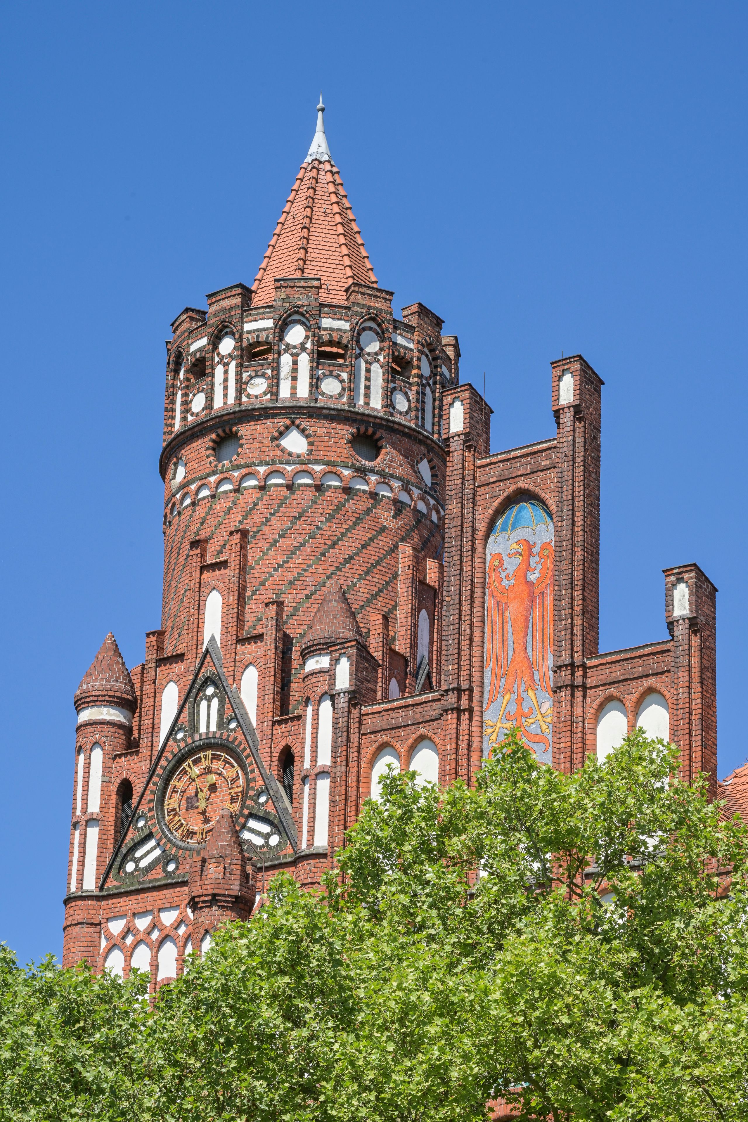Uma igreja histórica com uma torre alta, detalhada alvenaria e um grande vitral.