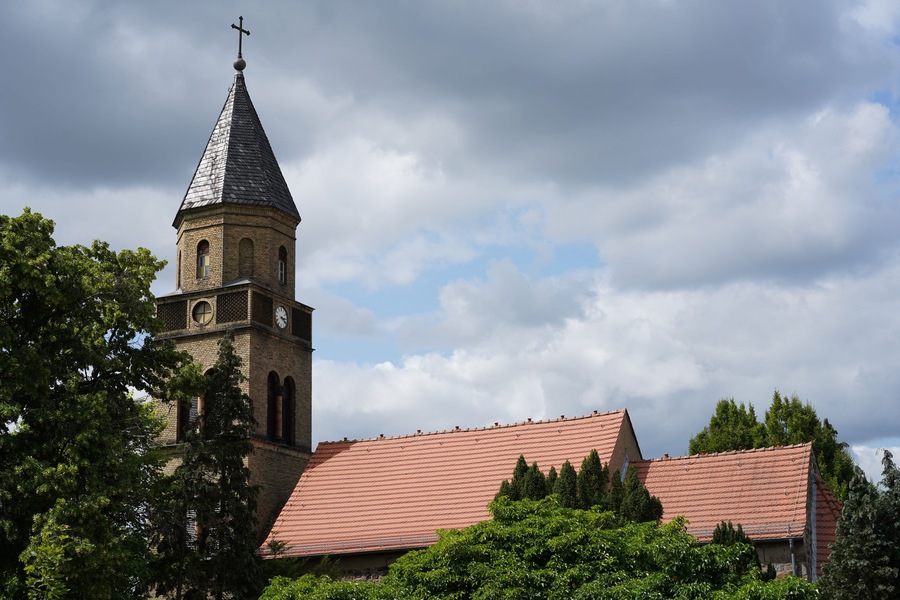 Eine Kirche mit einem hohen Kirchturm und einem Glockenturm.