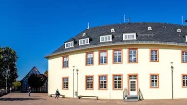 Un grand bâtiment jaune, avec un toit noir et une tour ronde.