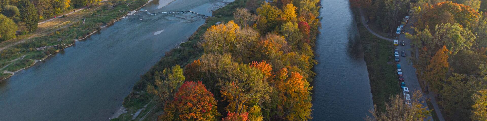 A river winding through a densely wooded area with autumn foliage.
