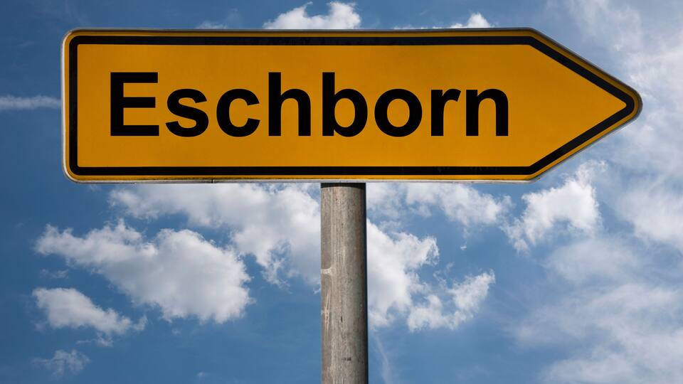 A directional sign with the word "Eschborn" pointing to the right.