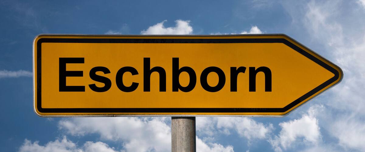 A directional sign with the word "Eschborn" pointing to the right.