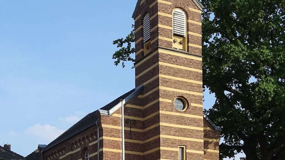 A church with a tall steeple and a brick facade.