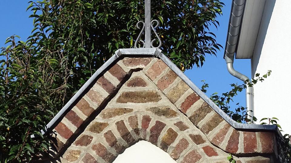 A brick archway with a cross on top and the words "13. Station" below.