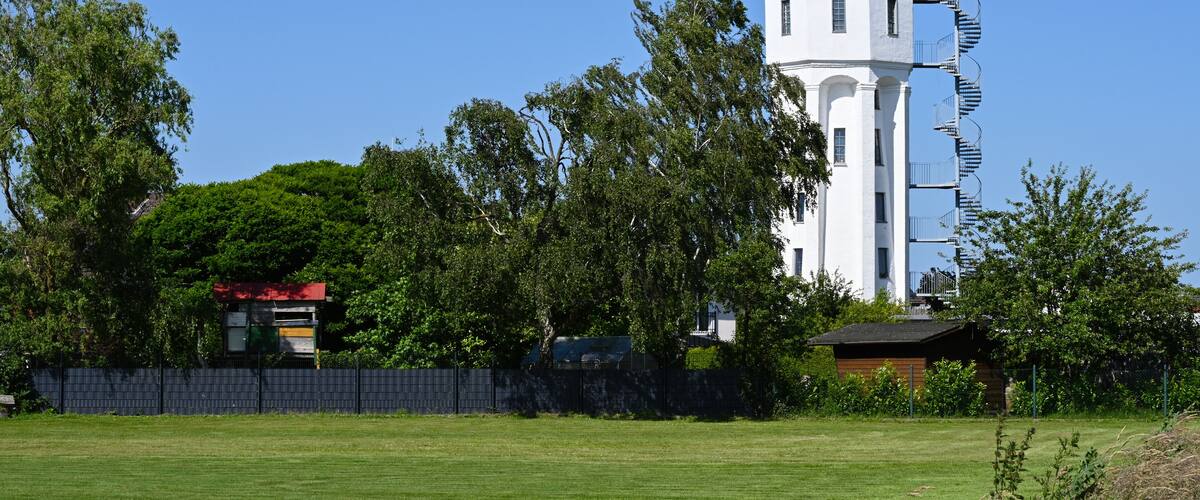 A white tower with a black roof and a spiral staircase.