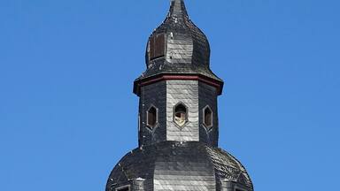 A church steeple with a weather vane and a star-shaped finial.