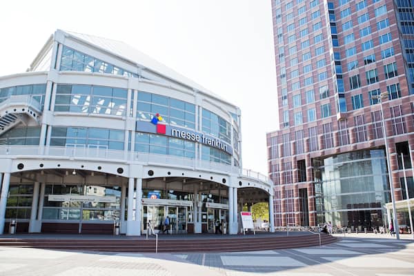 A modern building with a sign reading "messe Frankfurt" and a large glass facade.
