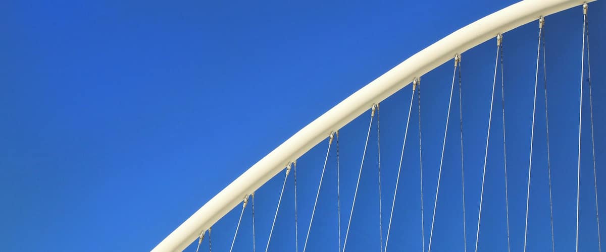A white cable-stayed bridge against a clear blue sky.