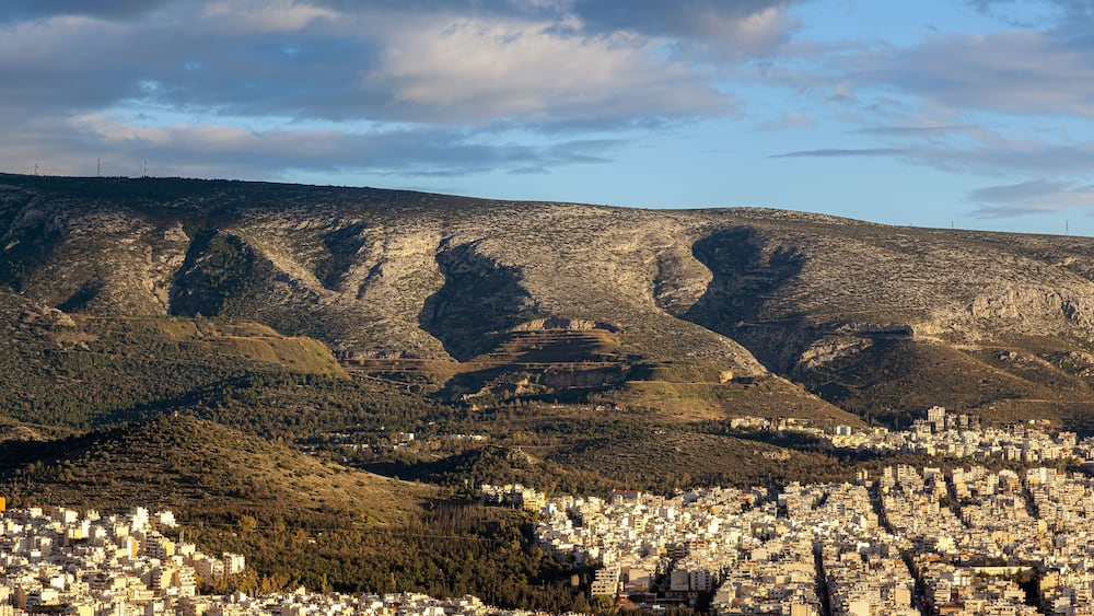 Majestic sunset with marvellous clouds over Hymettus mount and Athens city, Greece. There are several districts included like Ilioupoli, Kesariani, Vyronas and Kareas.