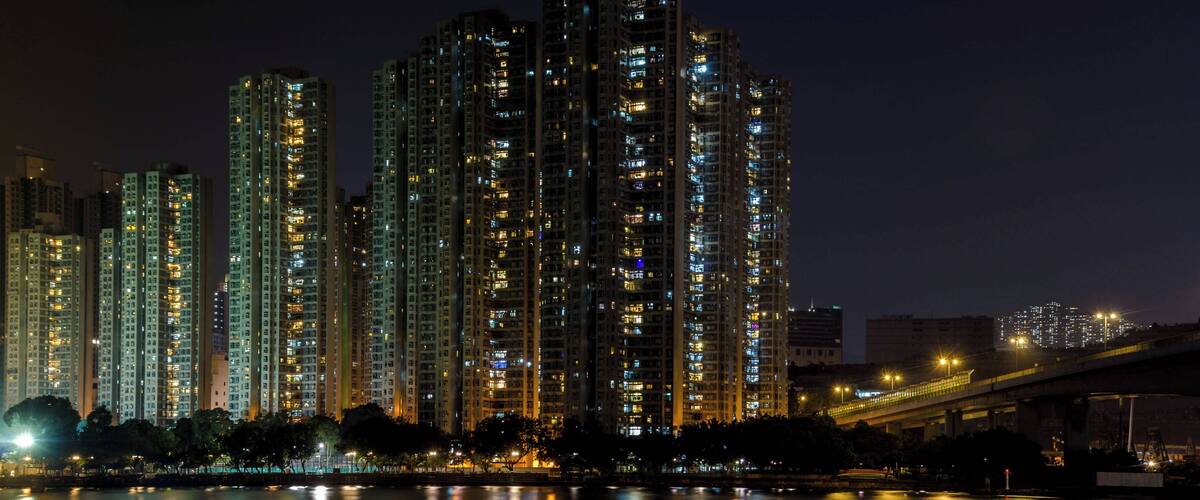 A nighttime view of high-rise buildings along a river in New Territories, Hong Kong.