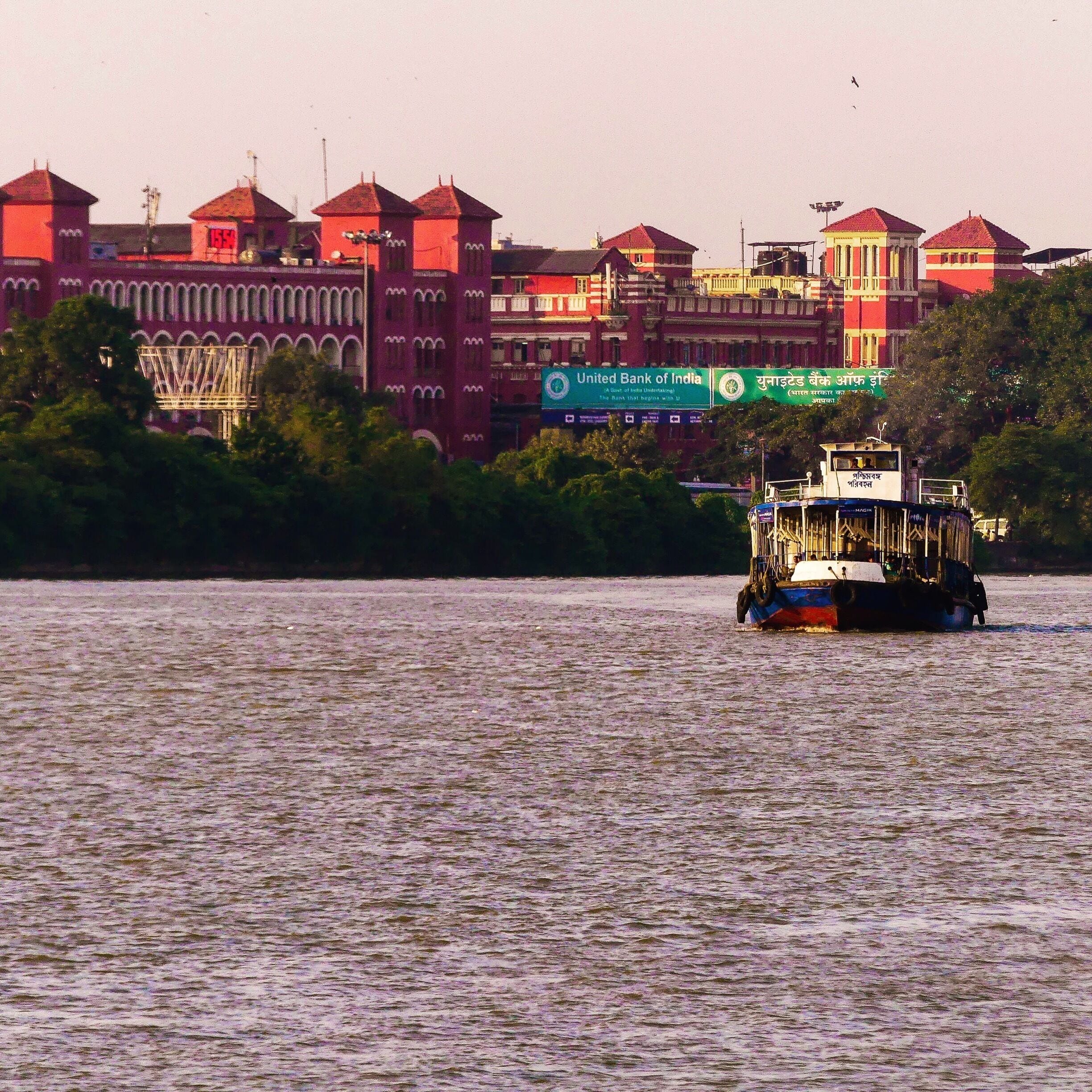 A boat on a river with buildings in the background.