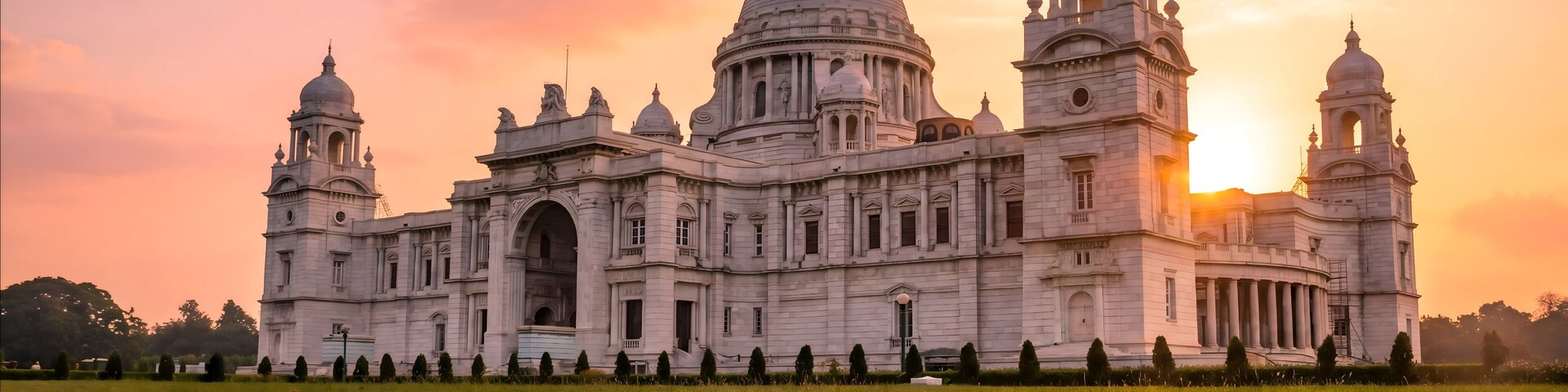 A large, ornate building with domes and towers, surrounded by a well-maintained lawn.
