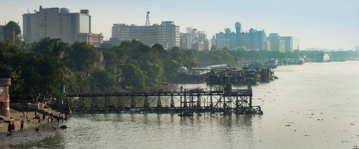 A river with a bridge, buildings, and trees along the banks.